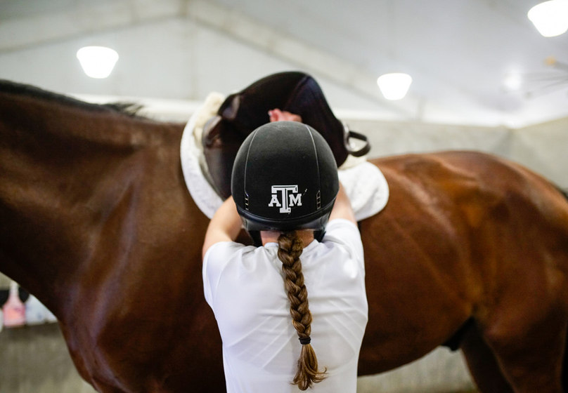 An equestrian athlete sharing a quiet moment with a horse